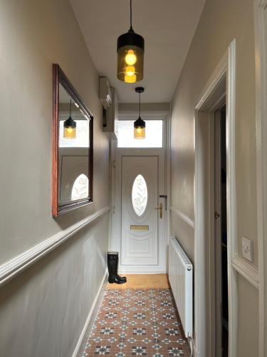 a hallway with a white door and a mirror at Beautiful 2 bedroom townhouse. in Darlington