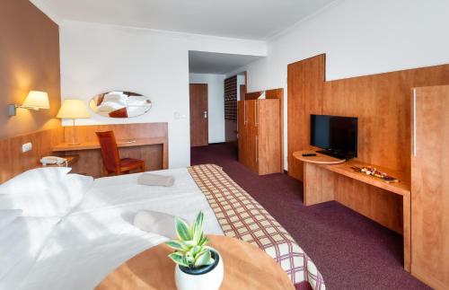 a hotel room with a bed and a tv at Hunguest Hotel Pelion in Tapolca