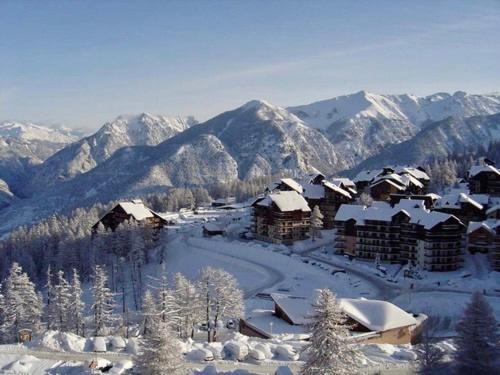 een met sneeuw bedekt dorp met bergen op de achtergrond bij RISOUL - Résidence ALTAIR - 5 couchages - À 1min à pieds des pistes in Risoul
