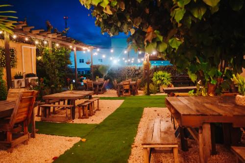 a patio with picnic tables and lights at night at Hotel RH Boutique Aruba in Oranjestad