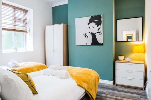 a bedroom with a bed and a blue wall at 1 bed central Newport Apartment, sleeps 3 in Newport