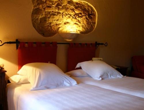 two twin beds in a bedroom with a light at Hotel Golf Can Rafel in Corbera de Llobregat