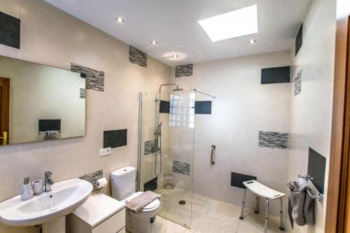 een badkamer met een douche, een toilet en een wastafel bij Villa Alegranza - LH190 By Villas Now Ltd in Playa Blanca