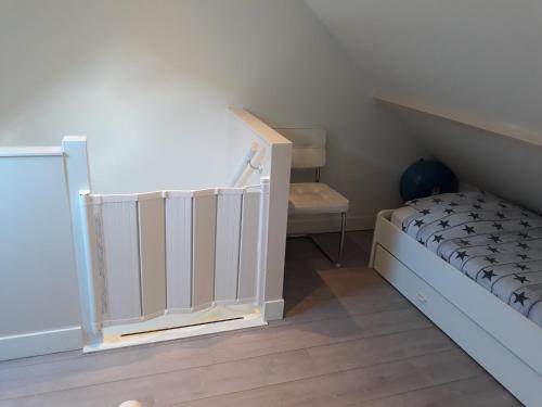 ein kleines Schlafzimmer mit einem Bett und einer Treppe in der Unterkunft Duinhuis26 in Egmond aan Zee