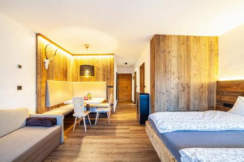 1 Schlafzimmer mit 2 Betten, einem Tisch und einem Sofa in der Unterkunft Ferienwohnung Kuppelwies 363 in Ulten