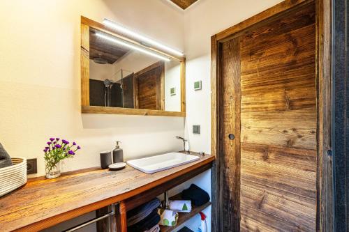 ein Bad mit einem Waschbecken und einem Spiegel in der Unterkunft Ferienwohnung Kuppelwies 363 in Ulten