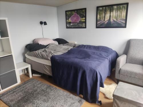 a bedroom with a bed and a couch and a chair at Linus och Lottas Frigga in Hällingsjö