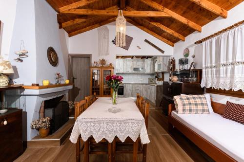 a kitchen and living room with a table with flowers on it at Villa Suzana in Mikros Prinos