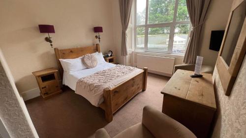 a small bedroom with a bed and a window at Broughton Craggs Hotel in Cockermouth