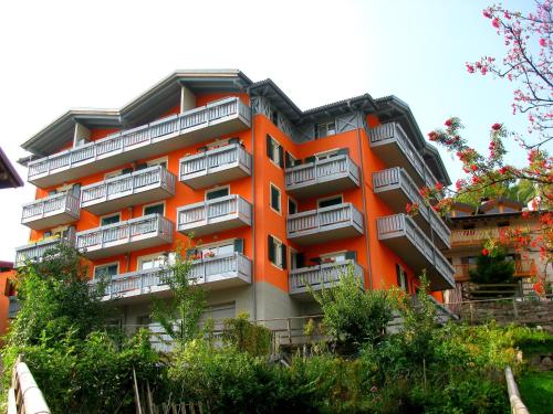 an orange building with balconies on the side of it at Appartamenti Residenza Dossalt in Baselga di Pinè
