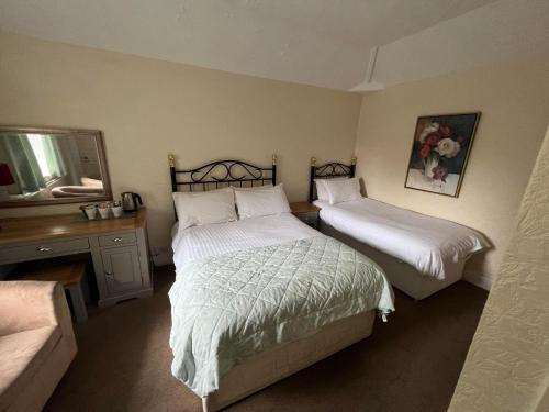 a bedroom with two beds and a couch at Broughton Craggs Hotel in Cockermouth