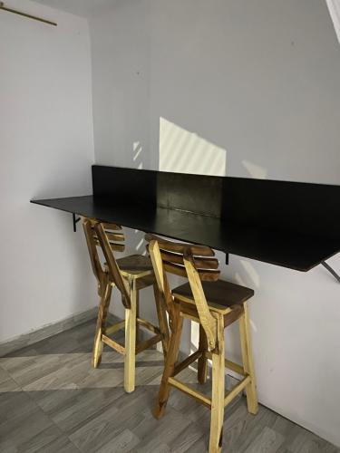 una mesa negra con dos sillas de madera alrededor en Aparta estudio, en Filandia