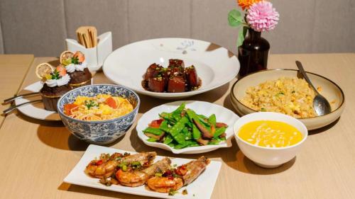 a table with plates of food and bowls of food at Holiday Inn Shanghai Dishui Lake by IHG in Nanhui