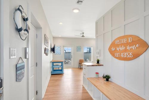 una cocina con armarios blancos y un cartel de madera en la pared en The White House, en Padre Island