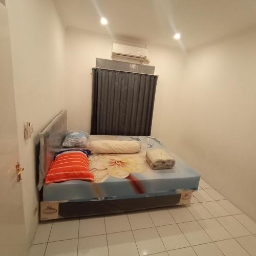 uma pequena cama num quarto com em Sewa Rumah Harian 3 BR di Bandung,Kiaracondong em Bandung