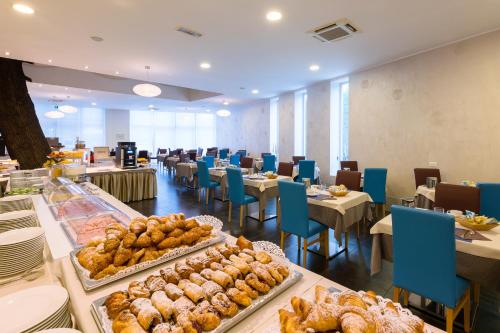 a restaurant with tables and chairs and food on display at Hotel Mioni Royal San in Montegrotto Terme