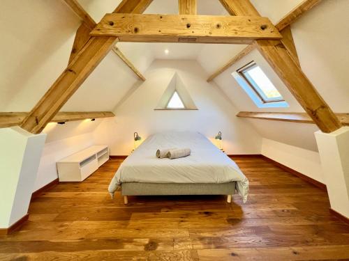 una camera da letto mansardata con letto e pavimenti in legno di COC - Villa La Finca ad Audembert