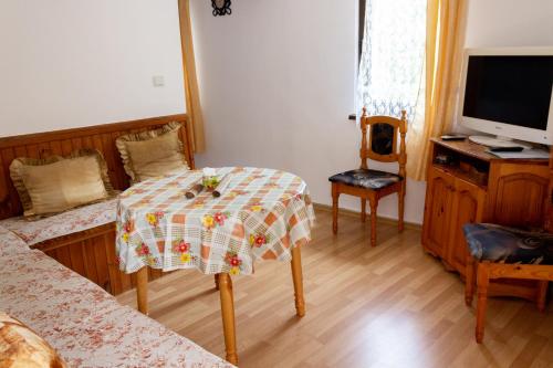 a small room with a table and a tv at Apartment R. Dermendzhiev in Melnik