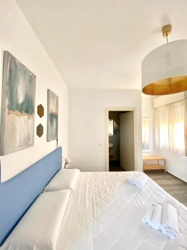 1 dormitorio blanco con 1 cama blanca grande y 2 toallas en RESIDENZA 8, en Rávena