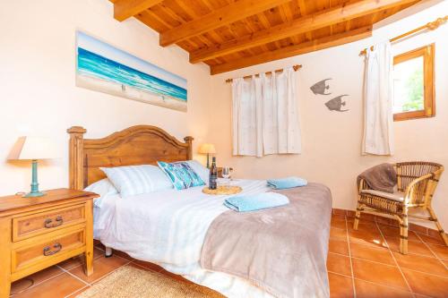 a bedroom with a bed and a desk and a chair at Surfescape Fuerteventura in Lajares