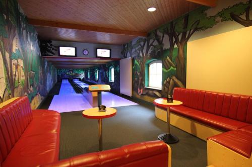 a bowling alley with red seats and a bowling alley at Rabenauer Mühle "bed & breakfast" in Rabenau