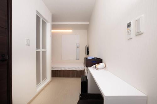 Kleines Zimmer mit einem Bett und einem Fenster in der Unterkunft Mutsumi Building - Vacation STAY 00543v in Tokio
