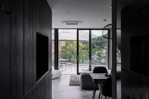 salon z telewizorem, stołem i krzesłami w obiekcie Stadthotel Goldenes Schiff w mieście Bad Ischl