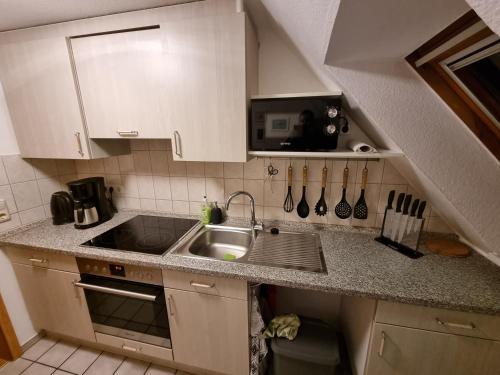 una pequeña cocina con fregadero y microondas en M&D ISKA VERMIETUNG, en Heide