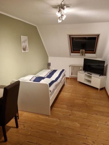 Schlafzimmer mit einem Bett und einem Flachbild-TV in der Unterkunft M&D ISKA VERMIETUNG in Heide