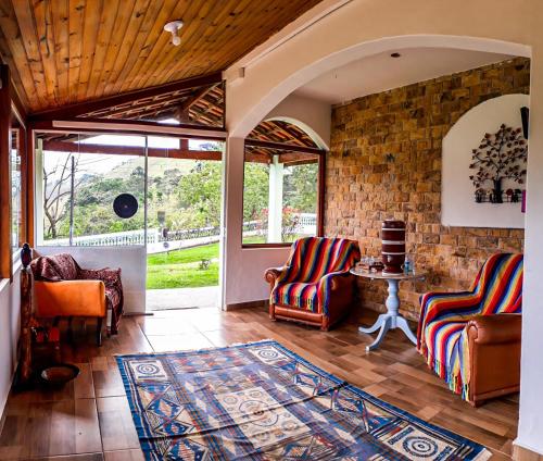 a living room with two chairs and a table at Pousada Ilumina in São Francisco Xavier