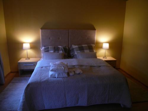 a bedroom with a large bed with two lamps at Apartments and Suites Kremnica in Kremnica