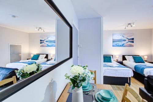 a living room with two beds and a mirror at Statera Apartments - Studio Apartment in Walworth in London