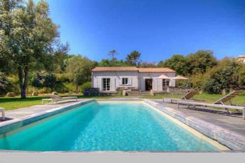 une piscine devant une maison dans l'établissement Domaine de Bracciole, à Corte