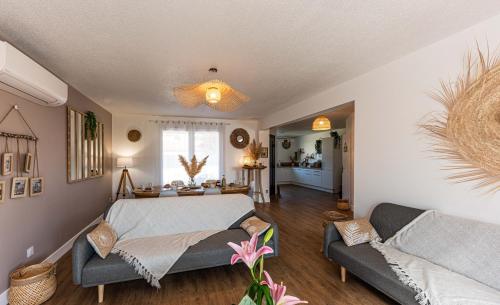 a living room with a bed and a couch at Villa des Oliviers : Sublime villa avec piscine chauffée et privée, terrasse de 185m² in Bon-Encontre