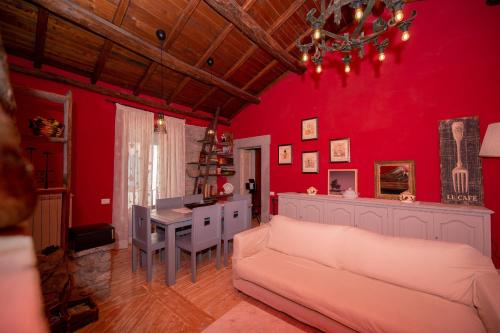 a living room with red walls and a couch and a table at Red Elegant and Charming Country House near Rome in Rocca di Papa