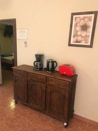 a wooden cabinet with two coffee makers on top of it at Complejo olivos in Las Grutas
