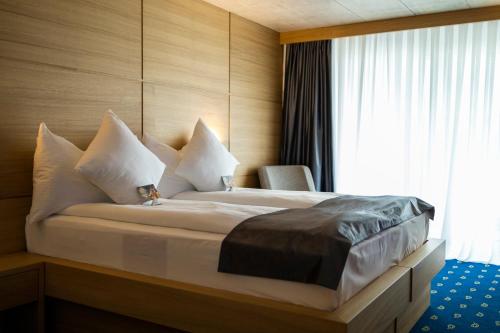 a bedroom with a large bed with a window at City Hotel Glarnerland in Näfels
