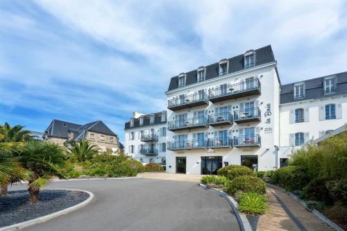a large white building with a street in front of it at Hôtel la Baie Valdys Resort & SPA in Douarnenez