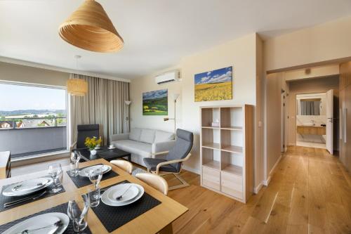 uma sala de estar com uma mesa de jantar e um sofá em Apartament Widokowy - Penthouse z tarasem em Kudowa-Zdrój