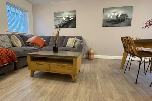a living room with a couch and a coffee table at Harbourside by Caithness Luxury Apartments NC500 - 2 Bedroom holiday home - Sleeps Work teams upto 2 & holiday makers upto 6 with bike store in Wick