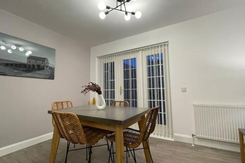 a dining room with a wooden table and chairs at Harbourside by Caithness Luxury Apartments NC500 - 2 Bedroom holiday home - Sleeps Work teams upto 2 & holiday makers upto 6 with bike store in Wick
