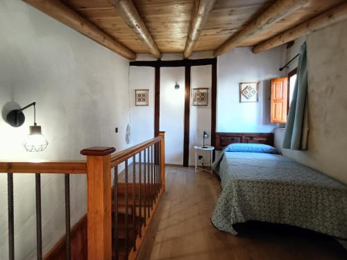 貝塞特的住宿－El Castellá，一间卧室设有一张床和木制天花板