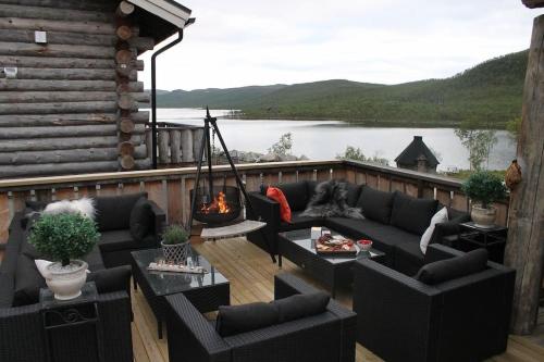 a deck with a couch and chairs and a fire pit at Kelo Aurora luxury cabin in Kilpisjärvi