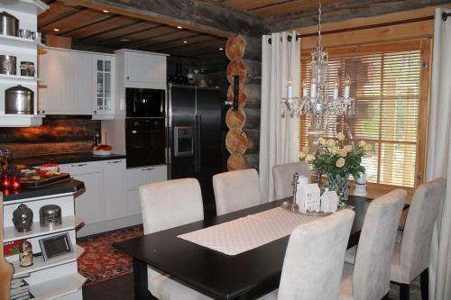 a kitchen with a black table and white cabinets at Kelo Aurora luxury cabin in Kilpisjärvi