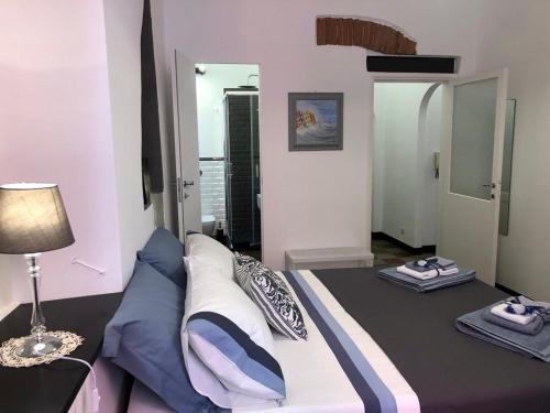 a bedroom with a bed and a table with a lamp at IN CANNETO...Genova nel cuore. in Genova
