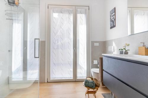 baño con aseo y puerta de cristal en Appartamento San Giovanni - Affitti Brevi Italia en Milán
