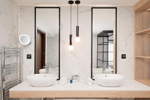 a bathroom with two sinks and a mirror at Radisson Blu Hotel, Cluj in Cluj-Napoca