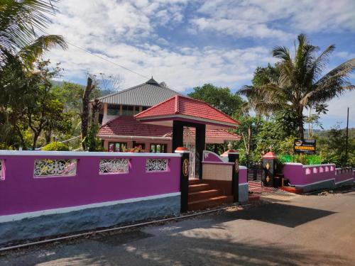 a small train station with a purple fence at Villoonnickal Homestay in Munnar