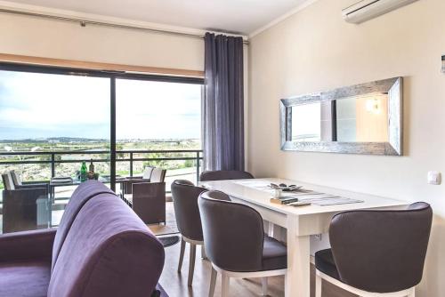 a dining room with a table and chairs and a large window at A Gaivota Ria Formosa Waterfront Lux Apart With Pool, Olhão, Algarve in Olhão