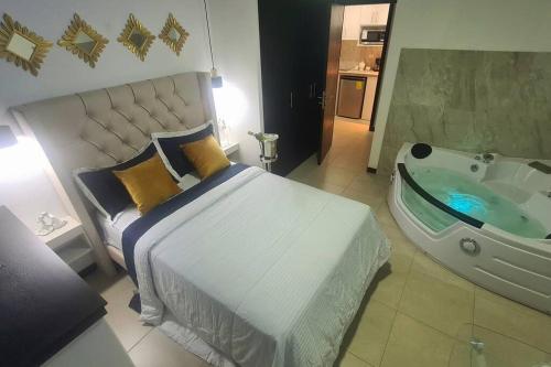 1 dormitorio con cama y bañera en Ecusuites Room Jacuzzi 105/2Hidromasaje Privado, en Guayaquil